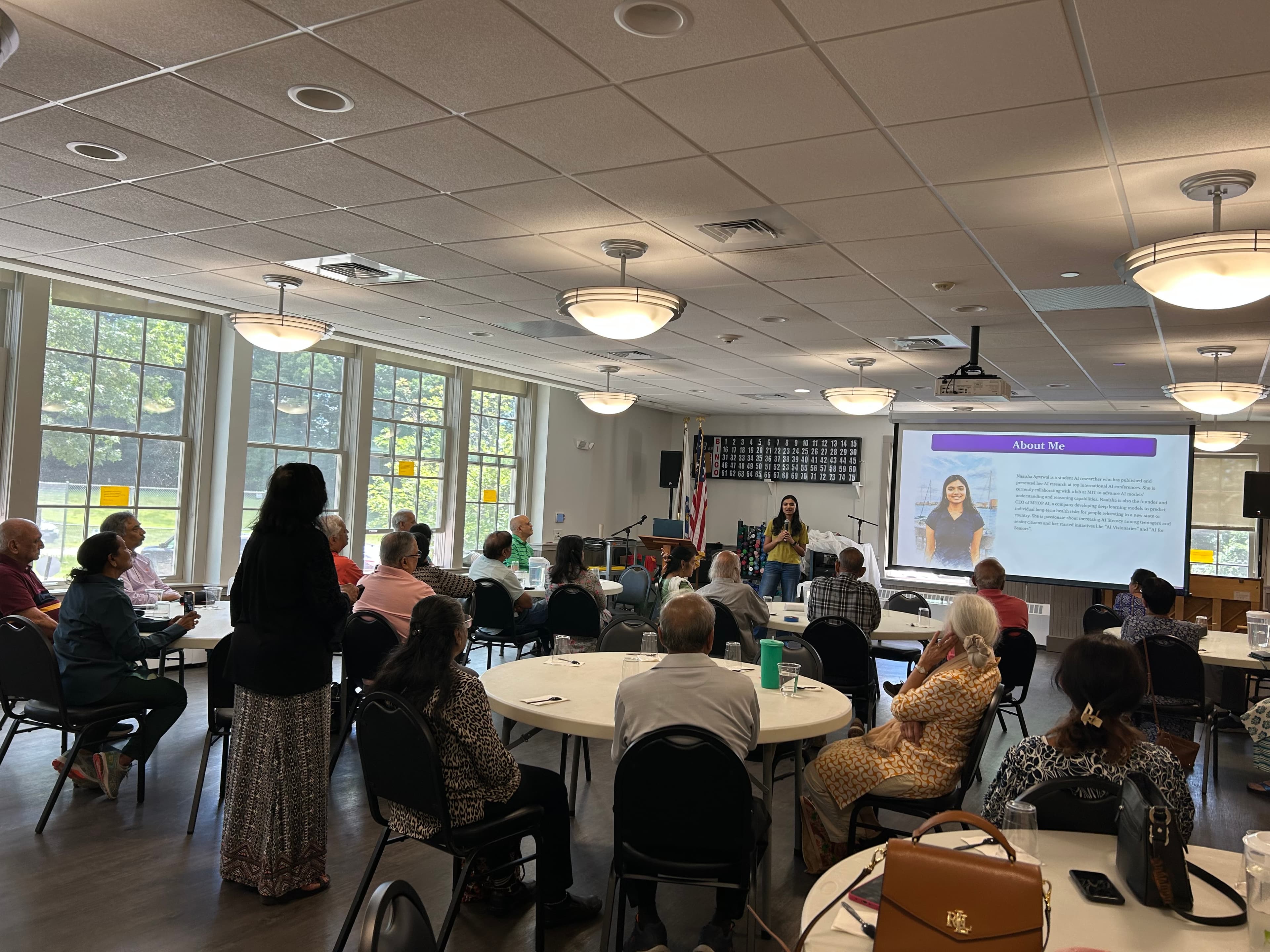 Seniors fill a community room as Naaisha leads an AI For Seniors workshop in Westford.