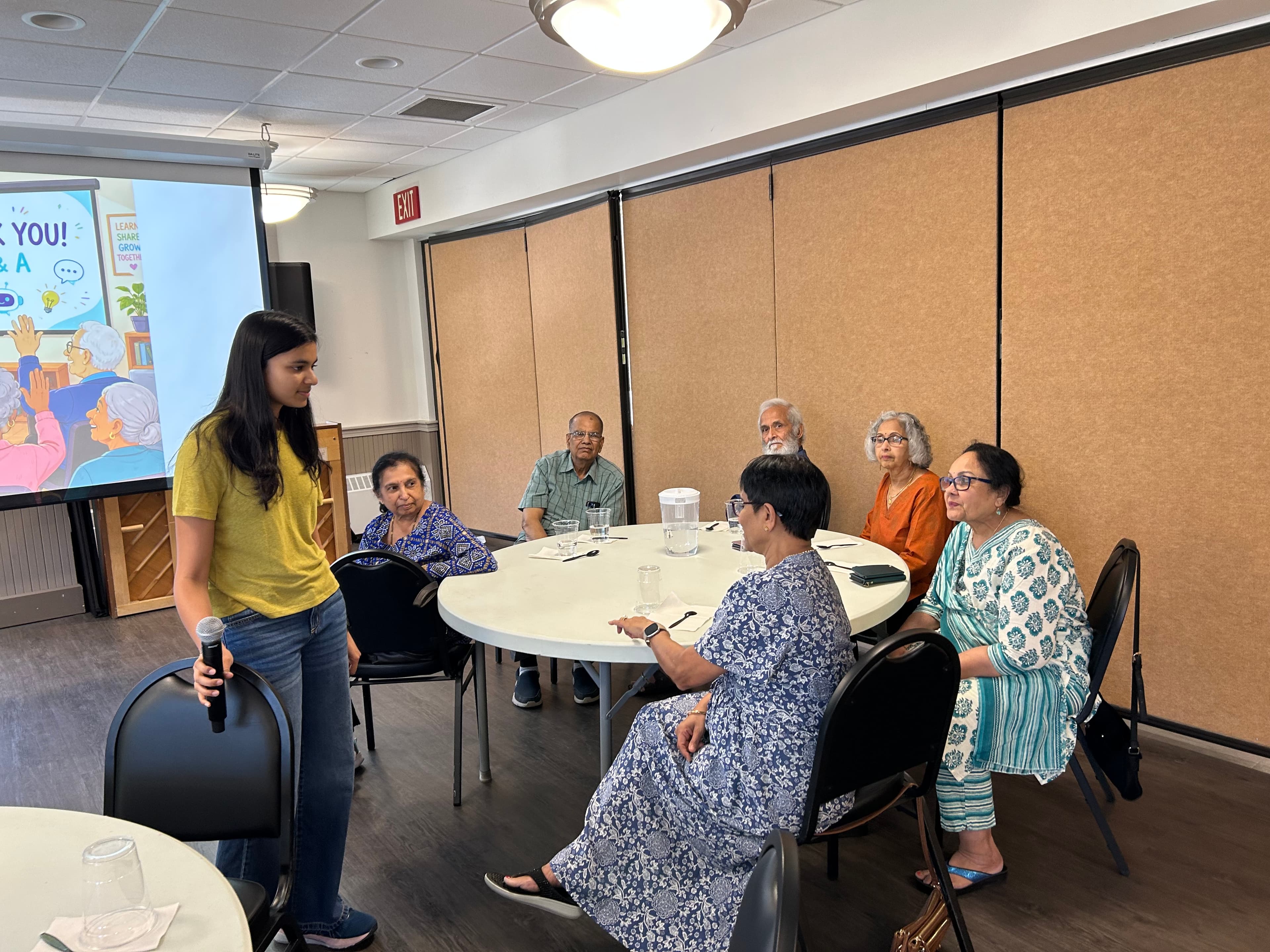 Naaisha listens as seniors lean in with questions during an AI For Seniors workshop in Westford.