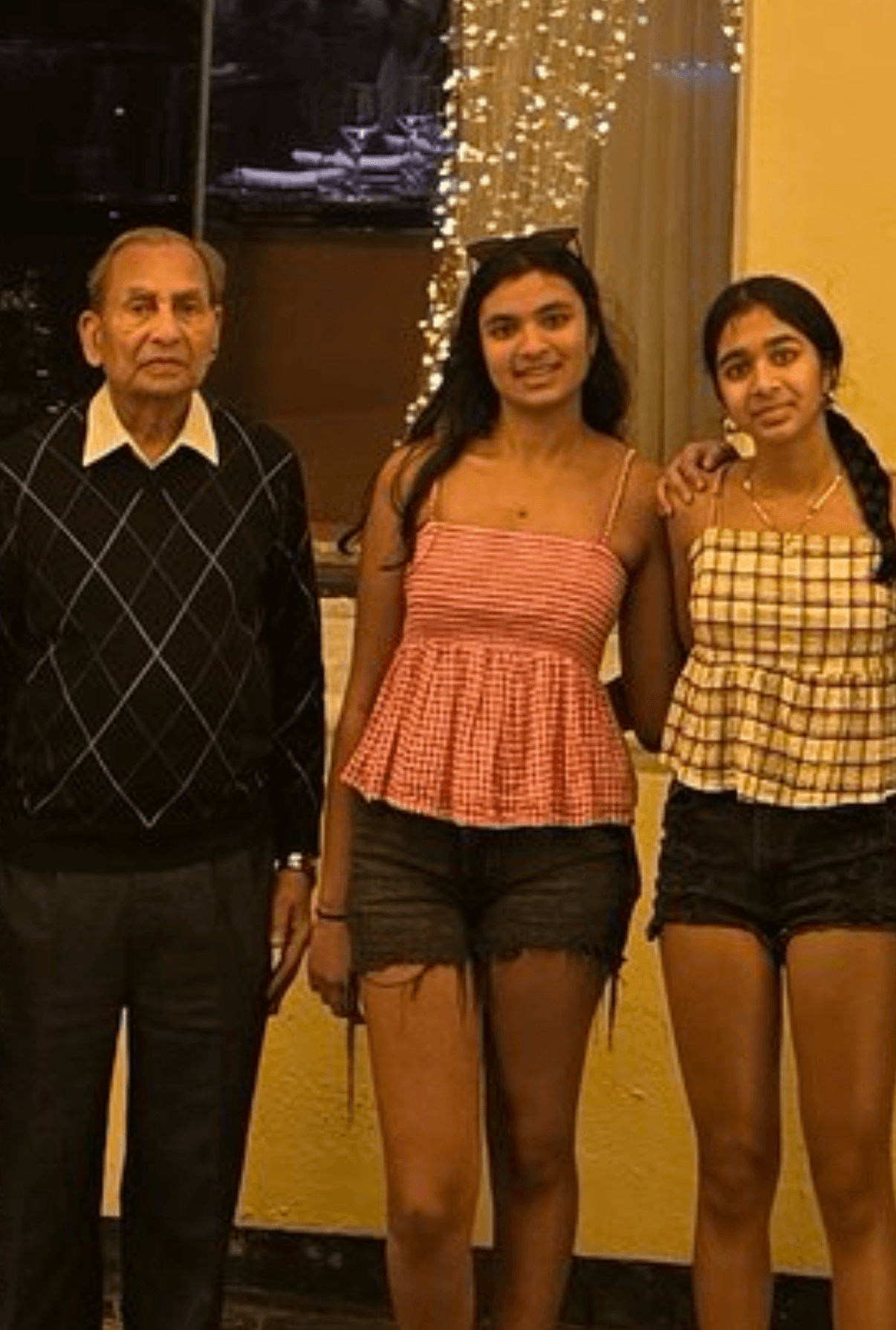 Naaisha, Sayoni, and their grandfather Daadu together at home.